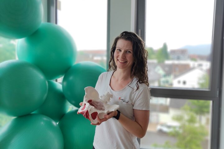 Rebecca im Kursraum mit einem Modell einer Hüfte in der Hand