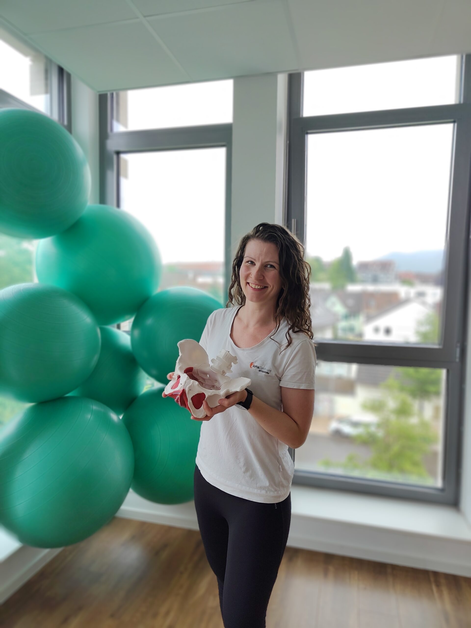 Rebecca im Kursraum mit einem Modell einer Hüfte in der Hand